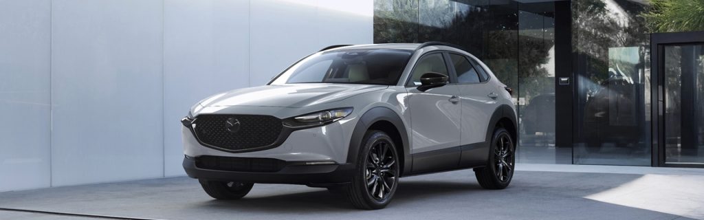 Light gray Mazda CX-30 parked outside a modern building