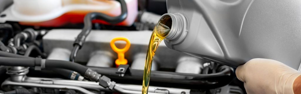 Pouring fresh motor oil into a car engine