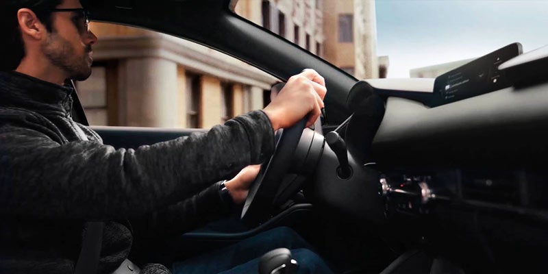 person's hands grasping the steering wheel of a 2024 Mazda3 Sedan