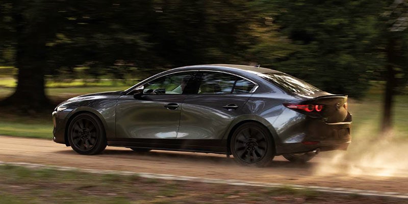 2024 Mazda3 Sedan driving on a dirt road